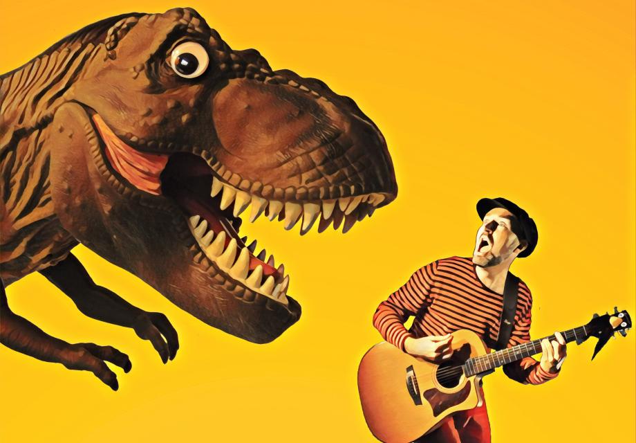 visar artisten Kapten Kapsyl, en man med gitarr och en dinosaurie