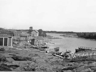 Dåvarande fyrhamnen där flera av bygnaderna och bryggor finns kvar idag (Foto: Ålands landskapsarkiv)